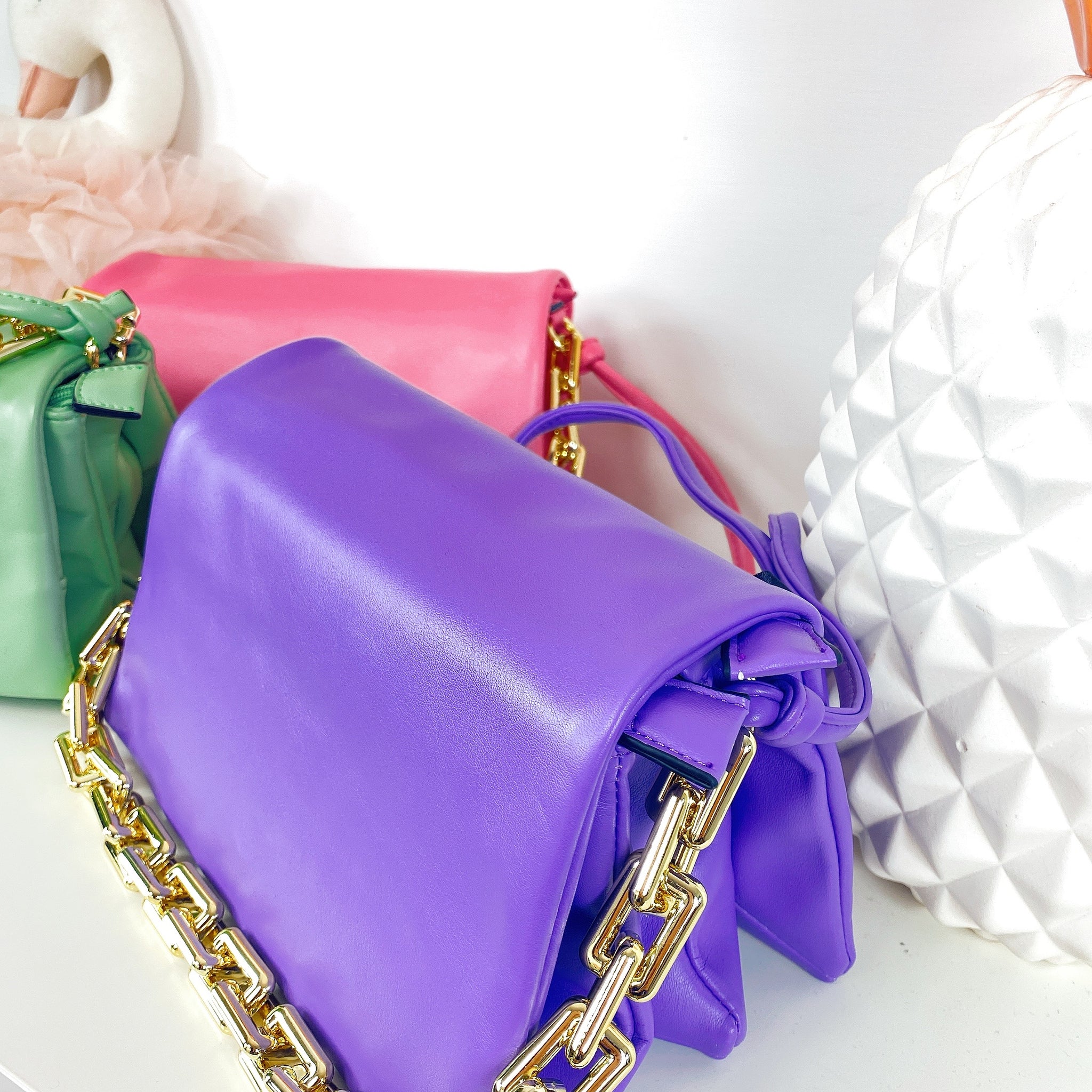 Clutch bag by hand with chain in bright colours